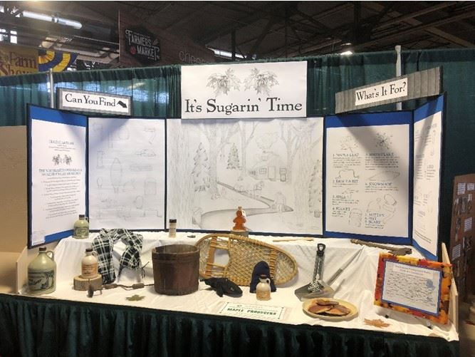A exhibit table containing maple sugaring equipment and products.