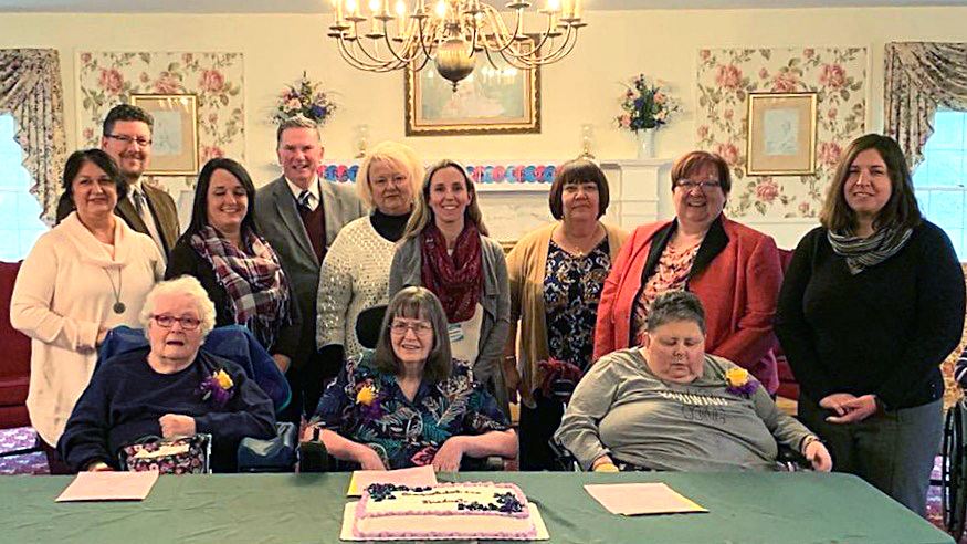 Three Ellen Memorial Health Care Center resident are congratulated by a group of local officials aft