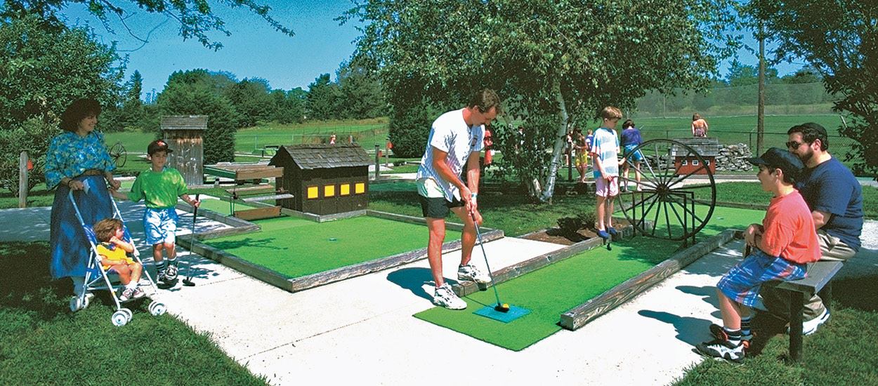 Family enjoying miniature golf at Carousel Water & Fun Park in Beach Lake.